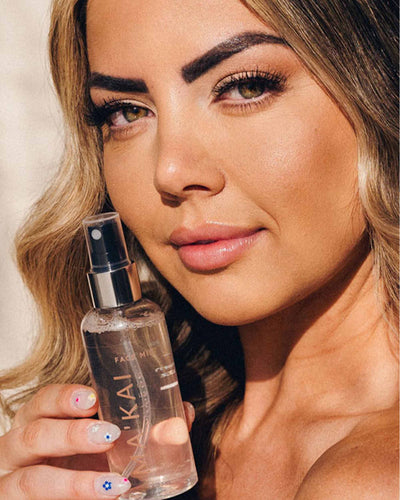Woman holding a skincare product with a blurred background