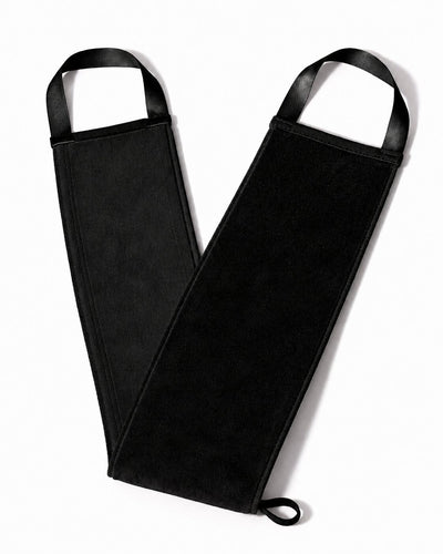 A black self tanning back mitt with arm guards and integrated black straps, laid flat on a white background.