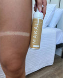 Person applying Makai Sunless tanning mist to their skin with a white background.
