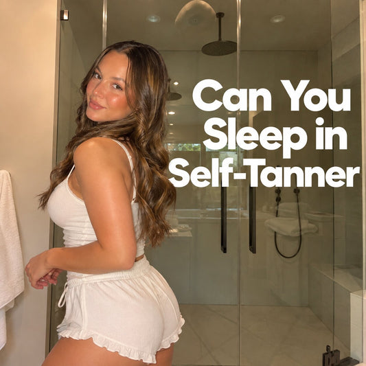 Woman standing in a bathroom wearing white pajamas after applying self tanner