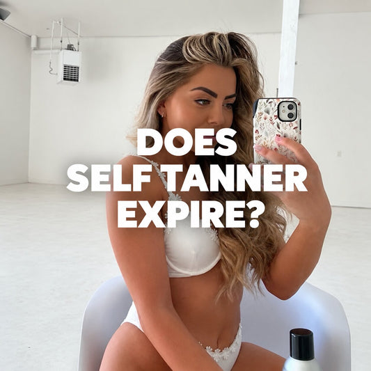 Woman taking a mirror selfie while holding a phone, with a self-tanner bottle visible in the foreground and text reading “Does Self Tanner Expire?”