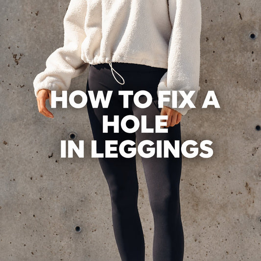 Woman wearing black leggings and a cream pullover standing against a concrete wall with text reading "How to Fix a Hole in Leggings."