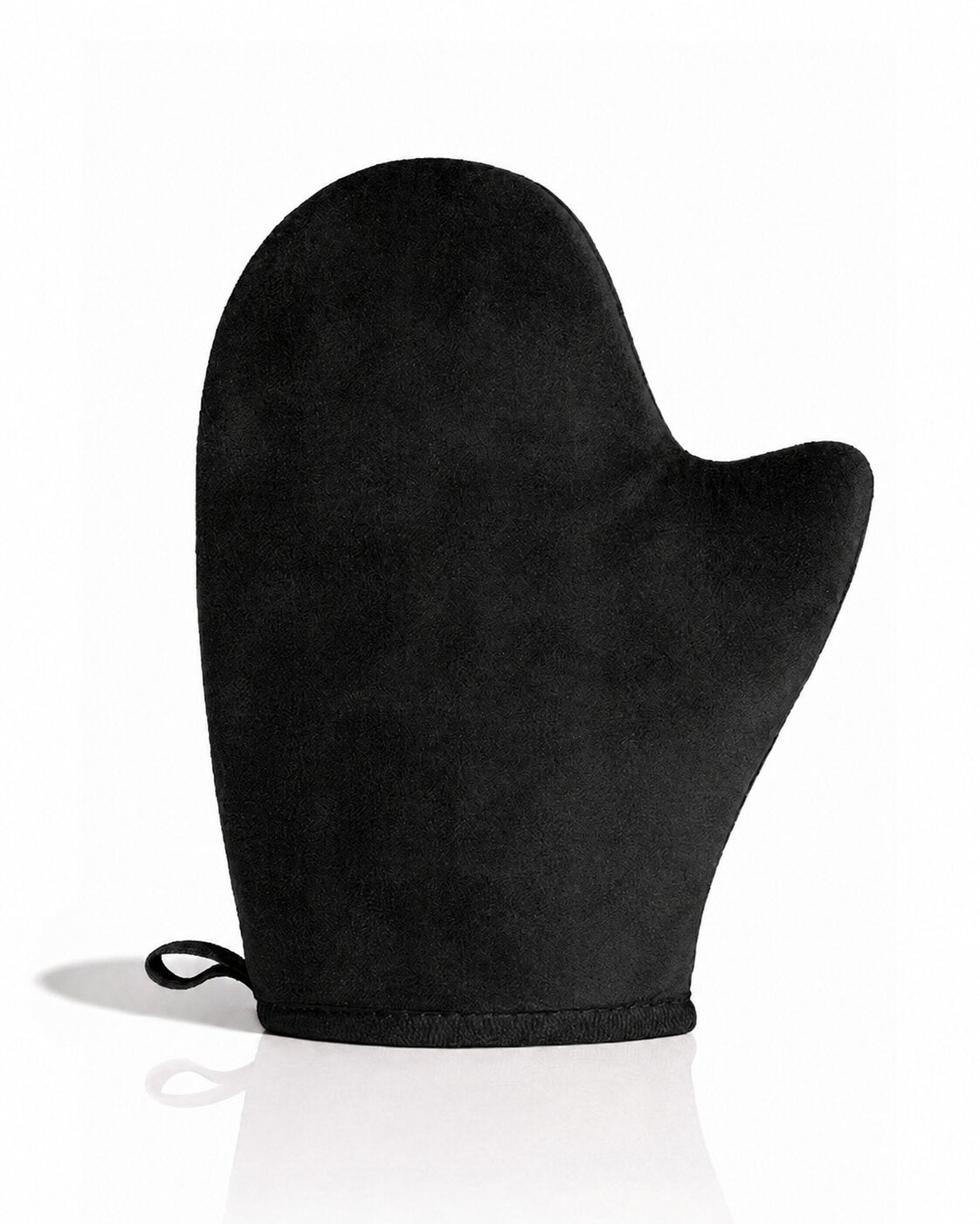 A single black self tanning mitt with a small hanging loop at the wrist, photographed on a clean white background with a soft reflection underneath.